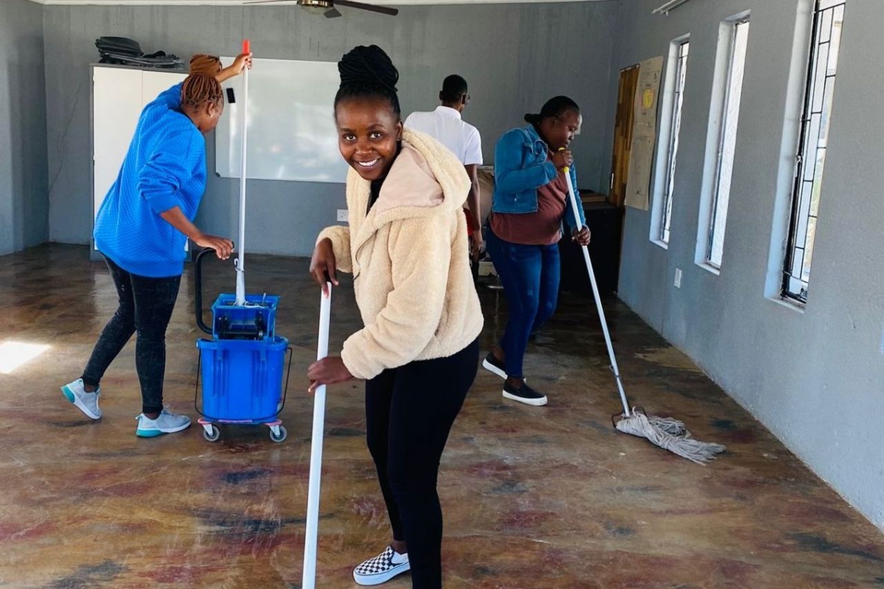 Facilitator Academy students clean learning centre